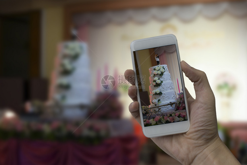 手握智能机在婚礼厅拍照大厅浪漫庆典一顿饭图片