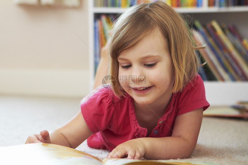 孩子年轻的青少女孩在卧室床上躺着的地板阅读书在室内图片