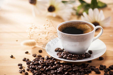 杯子咖啡和鲜花与晨光黑色的温暖图片