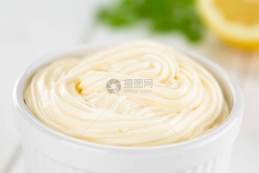 漩涡蛋黄酱在白色碗里柠檬和面在后的选择焦点中聚在图像的美乃滋间白色的图片