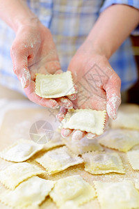 女饺子意大利拉维奥烹饪女人在切割板上放出新鲜的拉维奥利手图片