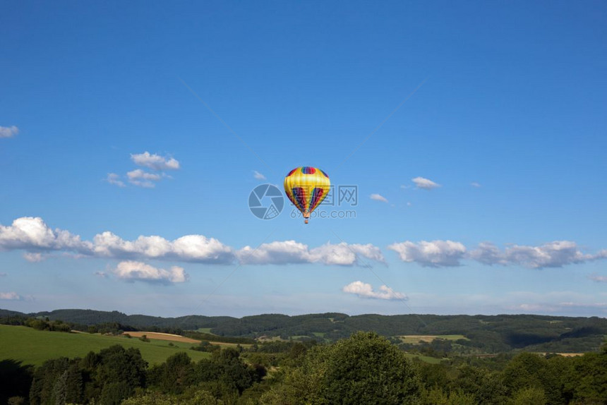 运动的热气球拍摄在无云的蓝天空上色热图片
