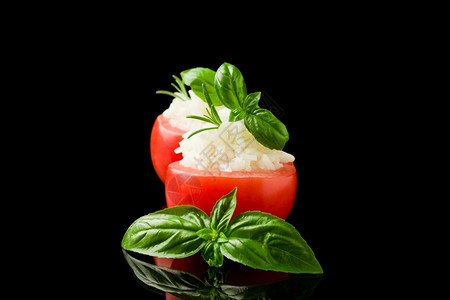 烹饪填充照片美味的塞满西红柿和黑色孤立背景的米饭香料图片