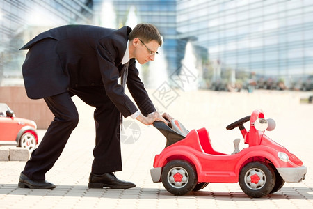 城市红玩具小车的成年大富人商轻的地位图片
