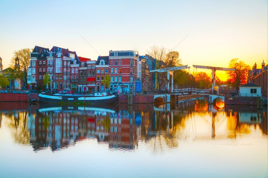 荷兰阿姆斯特丹市景色日出时与阿姆斯特尔河水荷兰语城市的图片