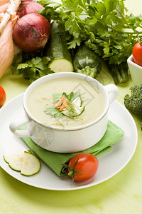 西兰花不同的绿色木制桌上蔬菜汤的素食相片不同蔬菜环绕着绿木桌稠密图片