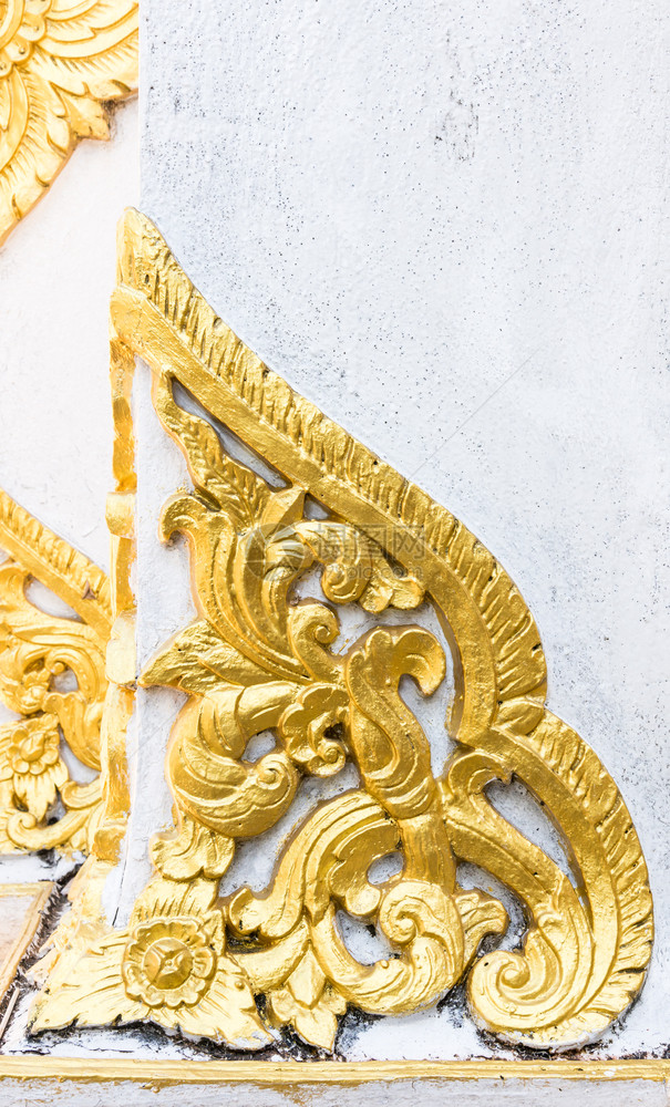 优质的金花和叶子在庙墙上以泰国传统风格的金花和树叶灰泥东方的图片