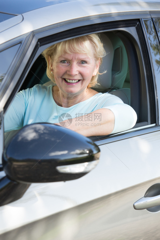 安全微笑的年长妇女驾驶汽车肖像快乐的相机图片