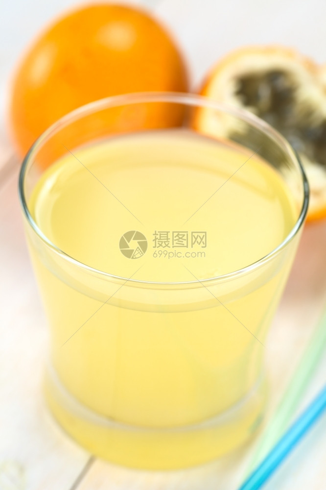 新鲜果汁由甜的花粉或葡萄汁制成放在玻璃中边有稻草后面颗粒水果后边有选择焦点重放在玻璃的前边缘西番莲轮茶点图片