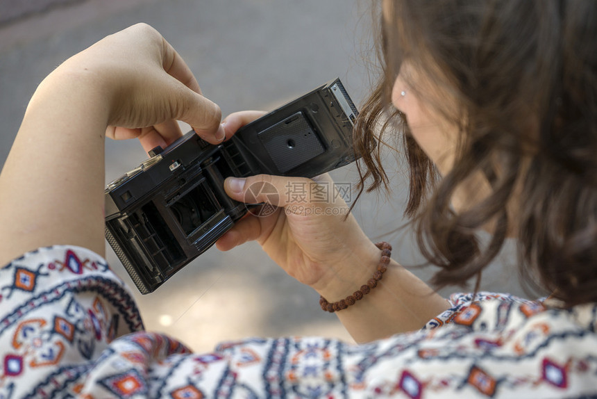 女人看着一个旧相机的后背随意模型技术图片