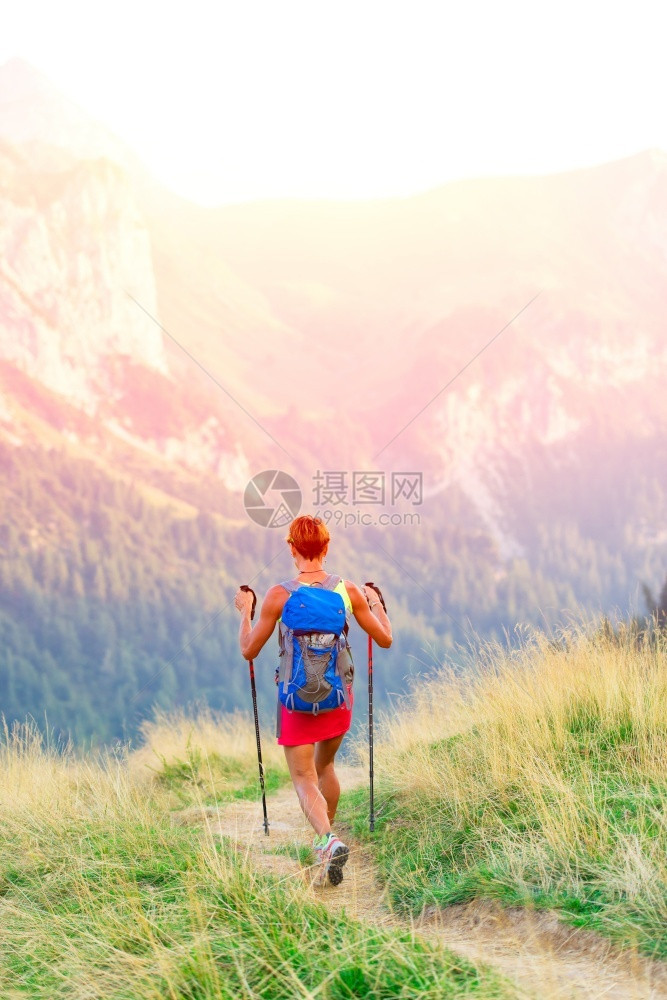 徒步旅行女士孤独山上登和北欧徒步拐杖的妇女远足者图片