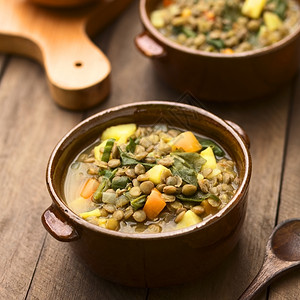 重点豆类由扁菠菜土胡萝卜和洋葱制成的蔬菜汤以黑棕碗为食用准备好的图片