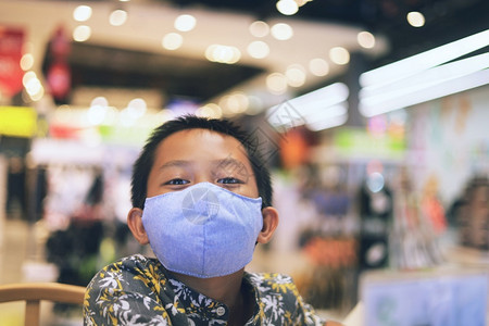 生病的流行在购物中心戴面罩的亚洲男孩具图片