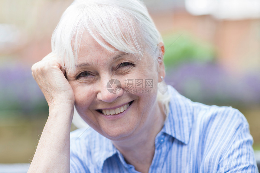 高龄妇女外头和肩部肖像微笑六十年代灰色的图片