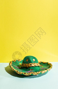拉丁穿几何黄色和绿柔调背景上的墨西哥草帽带墨西哥装饰品和的绿色帽子黄图片