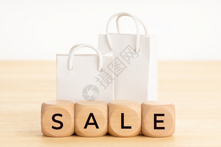 木制的堵塞关于块和桌子上的空纸购物袋白背景文字表格上的白背景零售图片