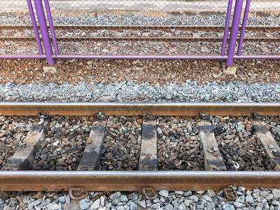 安全追踪火车站铁路线之间保护的金属栅栏铁围白色的图片