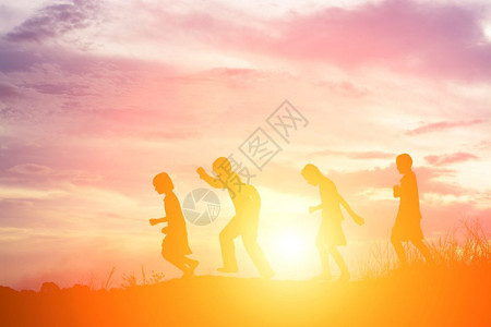 轮廓幸福儿童在暑夏日落的快乐时光中玩耍图片