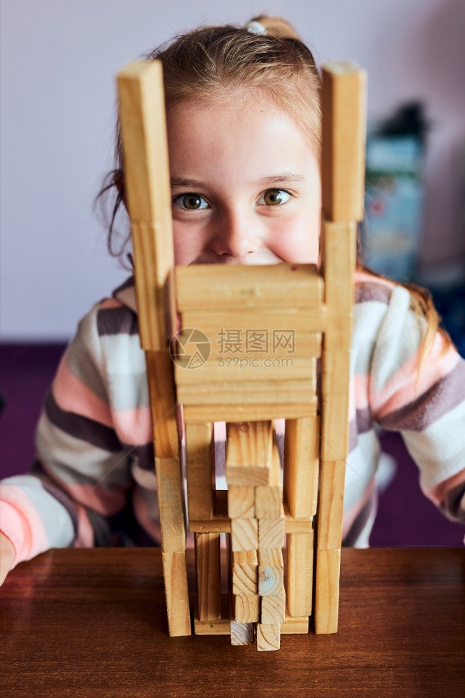 快乐的小女孩学龄前幼童玩木砖具建造一座塔构筑房子的概念活动喜悦图片