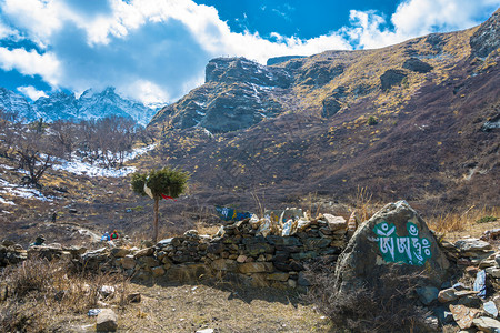 佛教尼泊尔山上的石头有彩色碑文在日出之晴天岩石图片