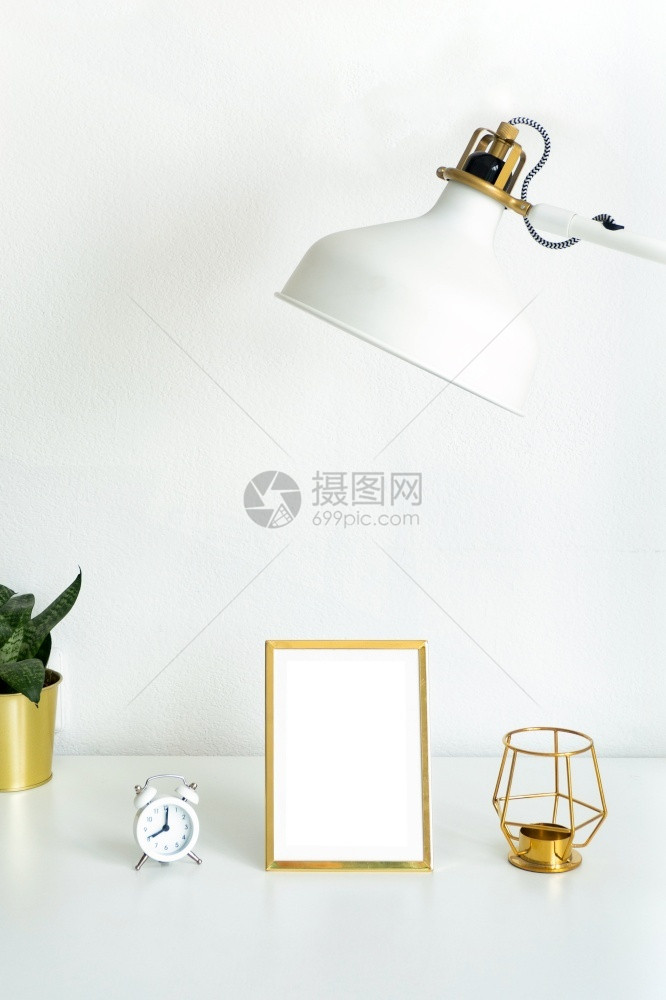 空的室内白桌上花朵白色闹钟金烛台和白灯上的模拟黄金照片框好的图片