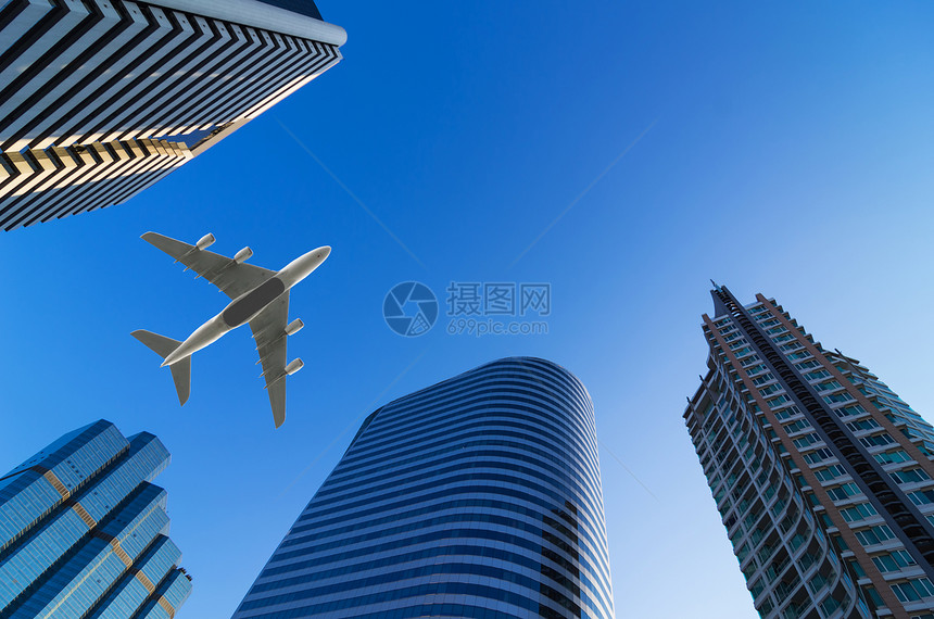 飞机越商业区现代大楼上空飞行的商营区机驾驶天空日落场图片