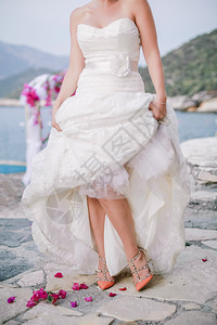 在海滩上穿着白裙子和鞋的新娘美丽幸福爱图片