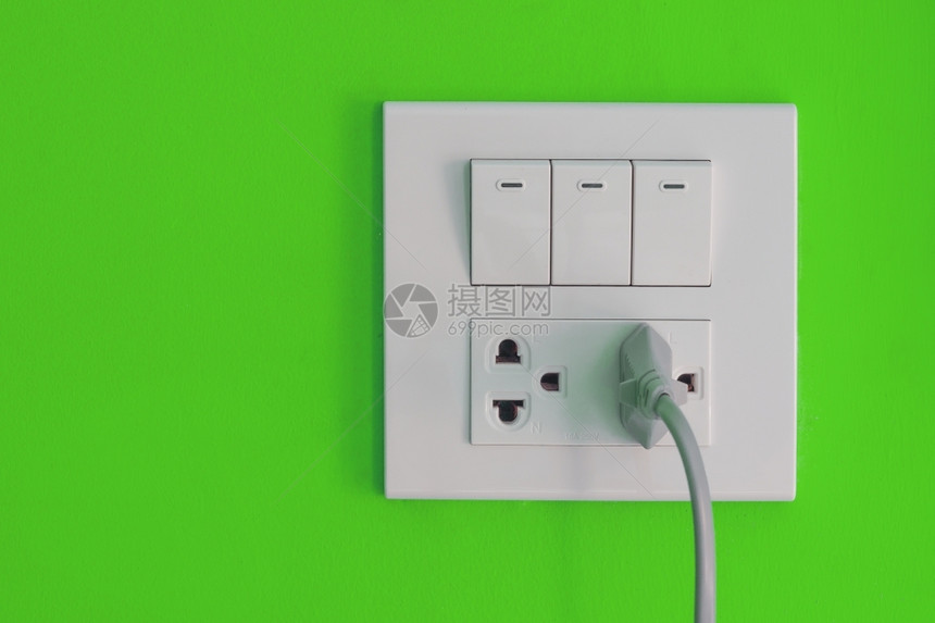 插头力量简单的在油漆绿色水泥墙上安装的白色电源和开关图片