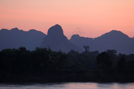 黎明薄雾轮廓美丽的风景清晨在河上长着双影山和树图片