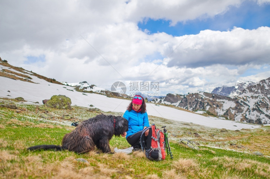 放松宠物一种在山上散步时一个女人从食物到狗图片