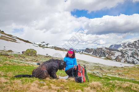 放松宠物一种在山上散步时一个女人从食物到狗图片
