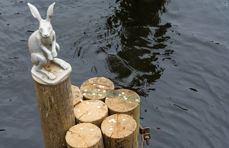 一个小雕塑只兔子在树的尽头闪光水中一个圆木尽端堡垒日志城市图片