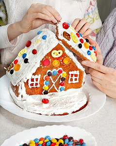 圣诞节曲奇饼外孙女和祖母做圣诞金饼屋的顶刨冰图片