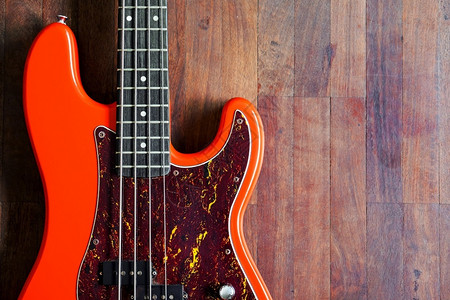 岩石乐器音木背景和复制空间的橙色电贝须吉他图片