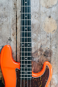 醋溜木须曼谷娱乐队木背景和复制空间的橙色电贝须吉他背景