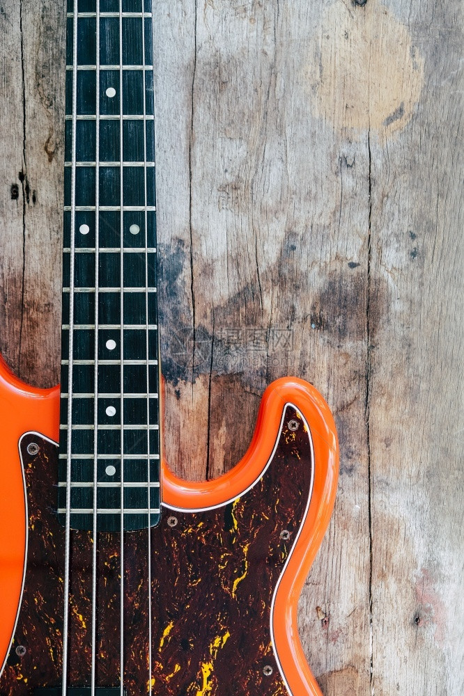 乐器木背景和复制空间的橙色电贝须吉他字符串手图片