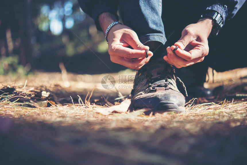 蕾丝绿色年轻登山男子在森林中放假背包时将鞋上的带系年轻登山男子在度假后把鞋上的带绑男人图片