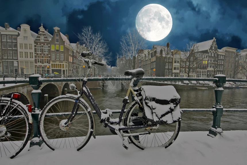 水建筑的传统荷兰寒冬夜间下雪的阿姆斯特丹市风景晚上图片