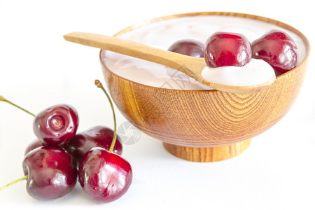 在木碗和勺子中配有酸奶的新鲜樱桃水果甜的美味食图片