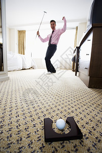 商人在酒店房间打高尔夫球时推杆玩高清图片