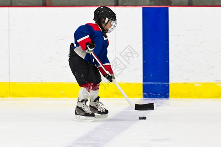 乐趣在冰球练习中男孩跟冰球滑溜曲棍孩子图片