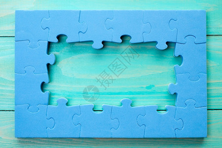 木制的团体合并蓝木背景上的Jigsaw拼图框架图片