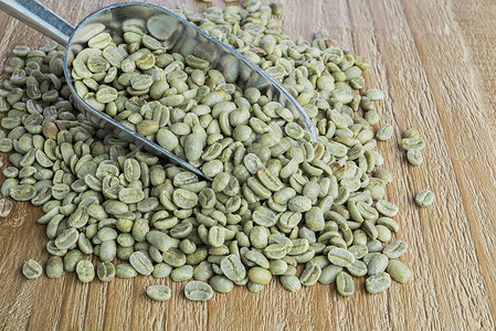 金属勺中的绿咖啡豆图片