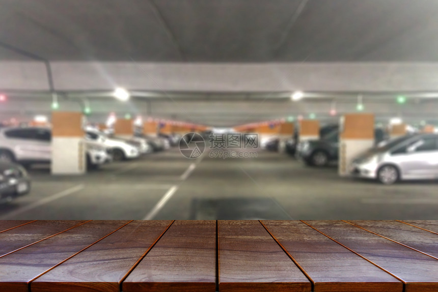 木制的城市停車處空木板桌间平台和在商场背景中模糊的停车场供产品展出时使用图片
