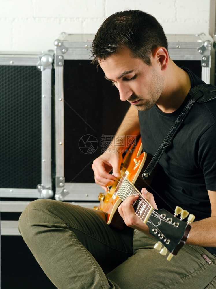 播放器排演吉他手一位坐在后台练习吉他的人相片图片