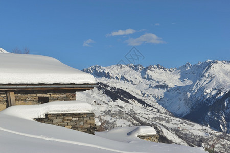 高山小屋覆盖着新的雪在蓝天下俯视山地景观寒冷的阿尔卑斯山蓝色的图片