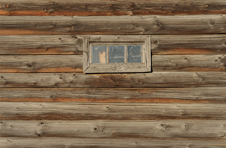 旧的未油漆logrrrcrquos墙板与小窗口的碎片粗糙硬木日志图片