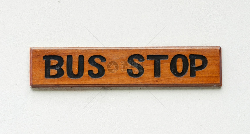 白墙上的木制公交车站标志一种上市城的图片