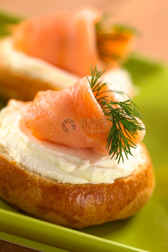 送达面包烟熏三文鱼和奶油酪甘蔗加选择焦点重在鲑鱼前面吸烟的番茄卷图片