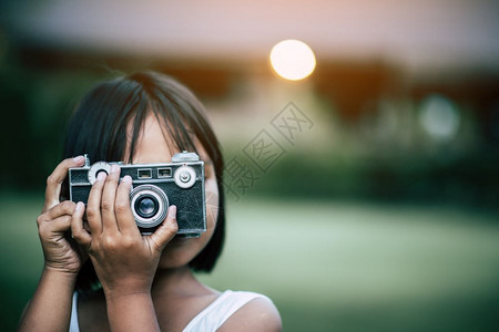 年轻的蝴蝶公园可爱小女孩用反光照相机拍片背景图片
